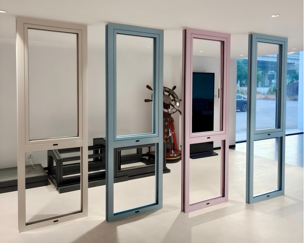 Showroom display of aluminum windows in pastel RAL colors including powder blue, soft pink, and warm gray