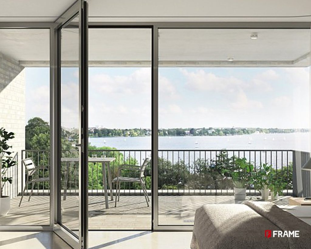 Aluminum swing door opening to a lake-view balcony in a modern bedroom