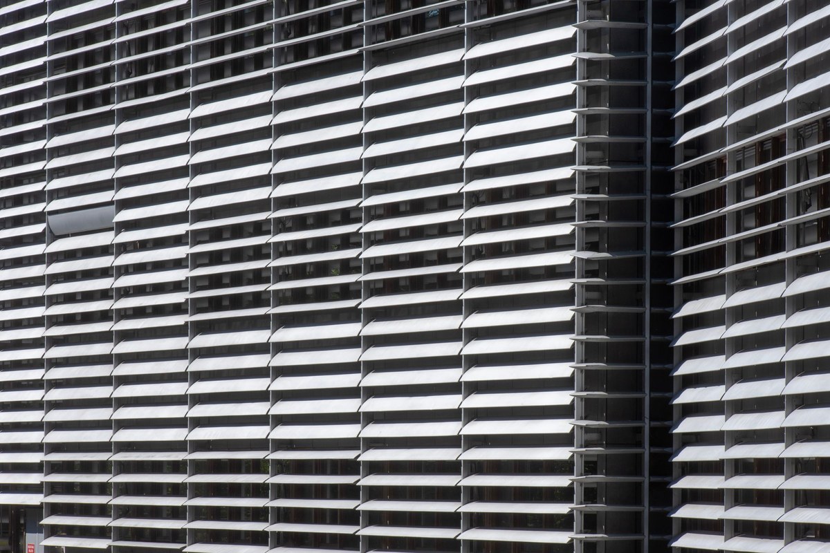 Louver blades set across a glazed facade as an exterior shading screen