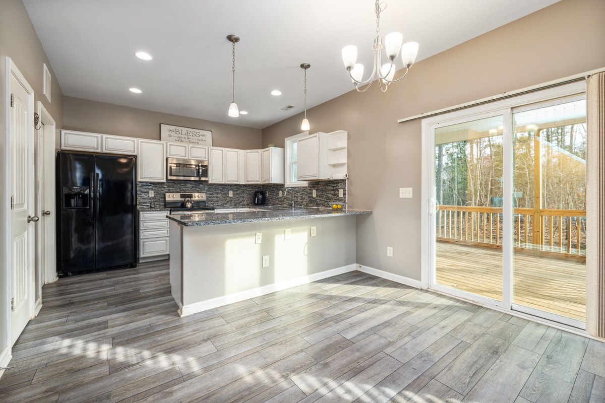 Kitchen opening onto a timber deck through a sliding glass door
