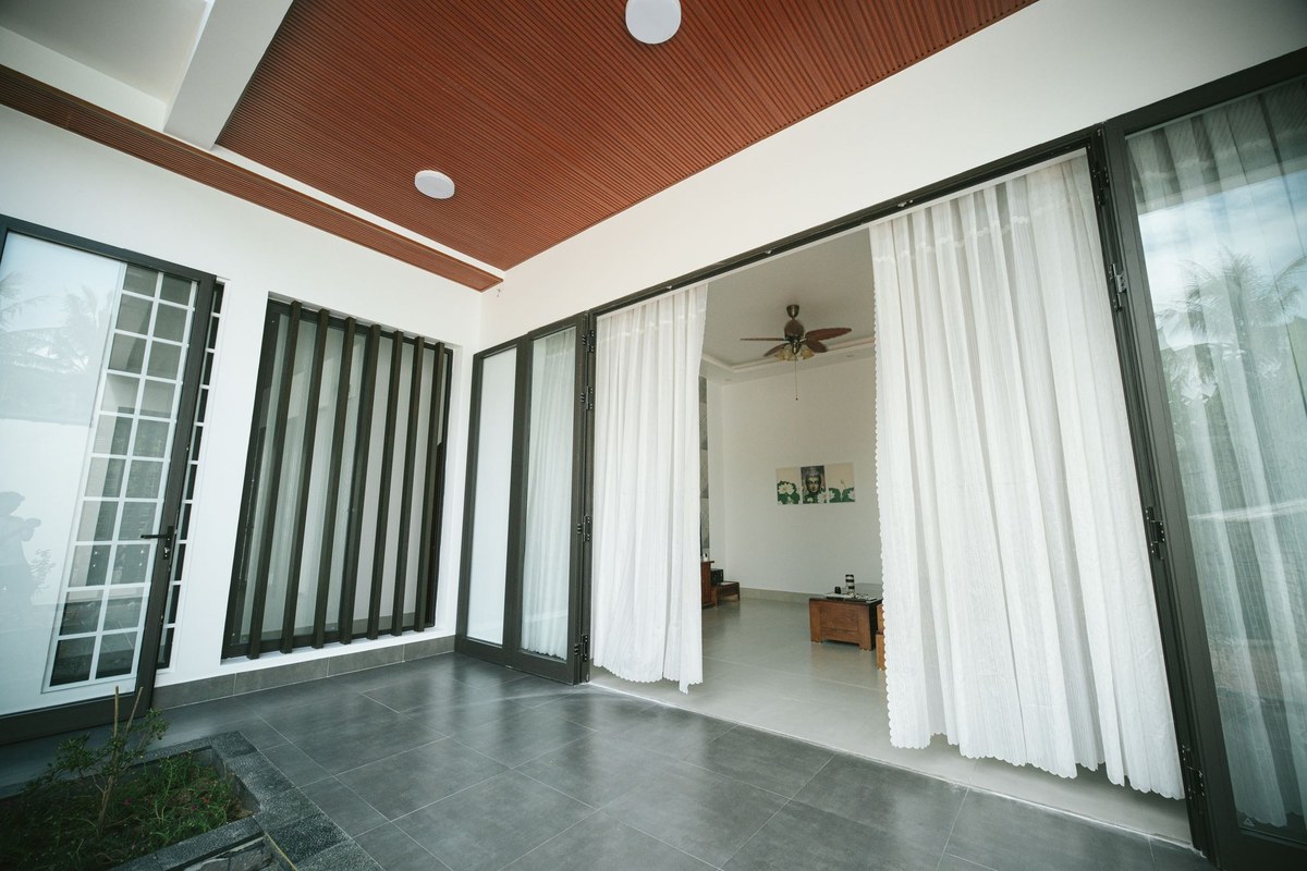 Large dark framed glazing panels opening a living space onto a patio